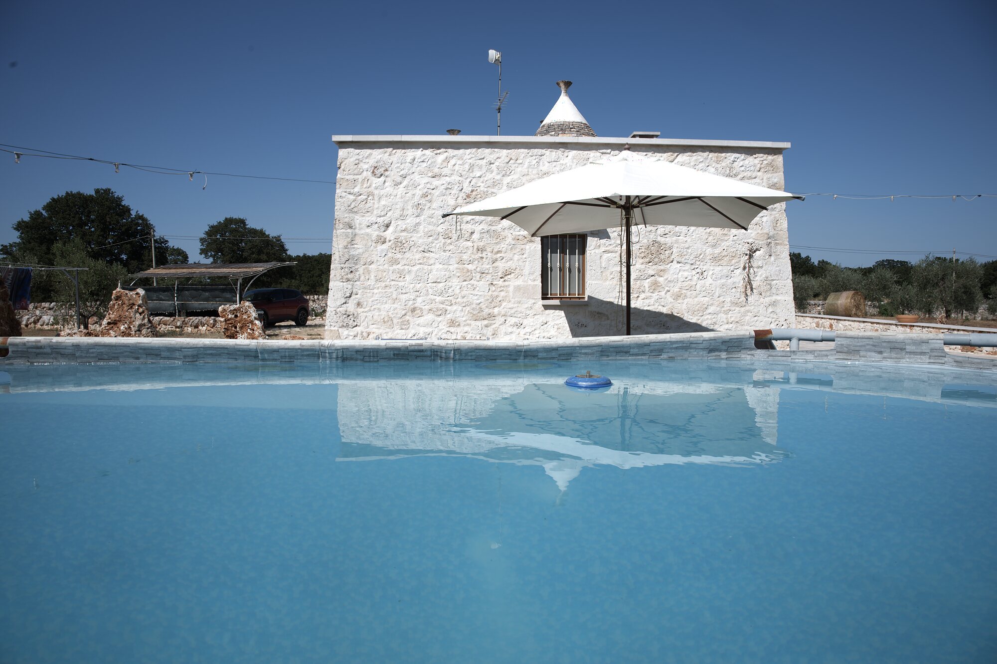 Trullo Libero — piscina con vista sul trullo in pietra