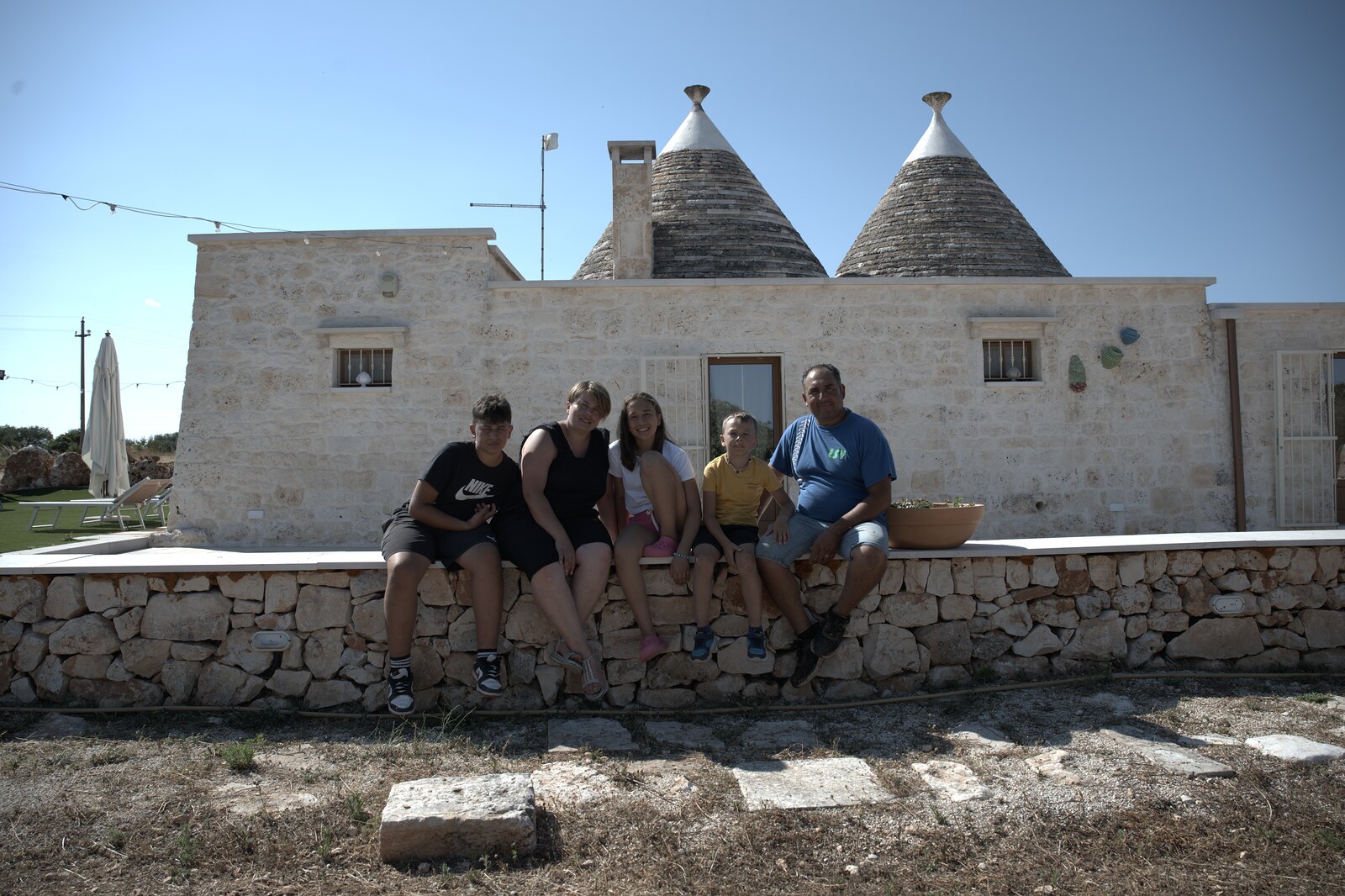 La famiglia di Trullo Libero davanti ai trulli in pietra