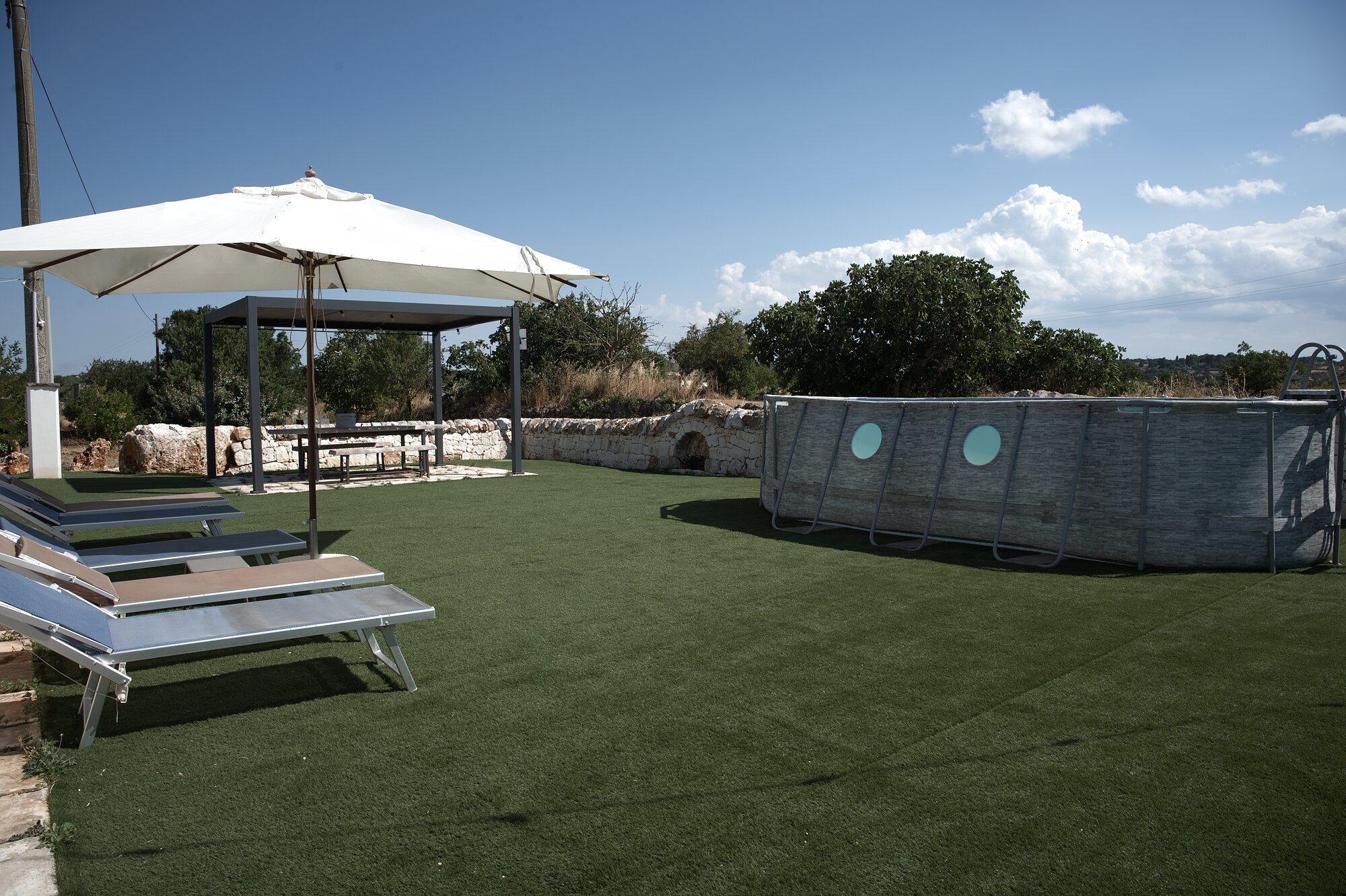 Trullo Libero — solarium con lettini e area relax